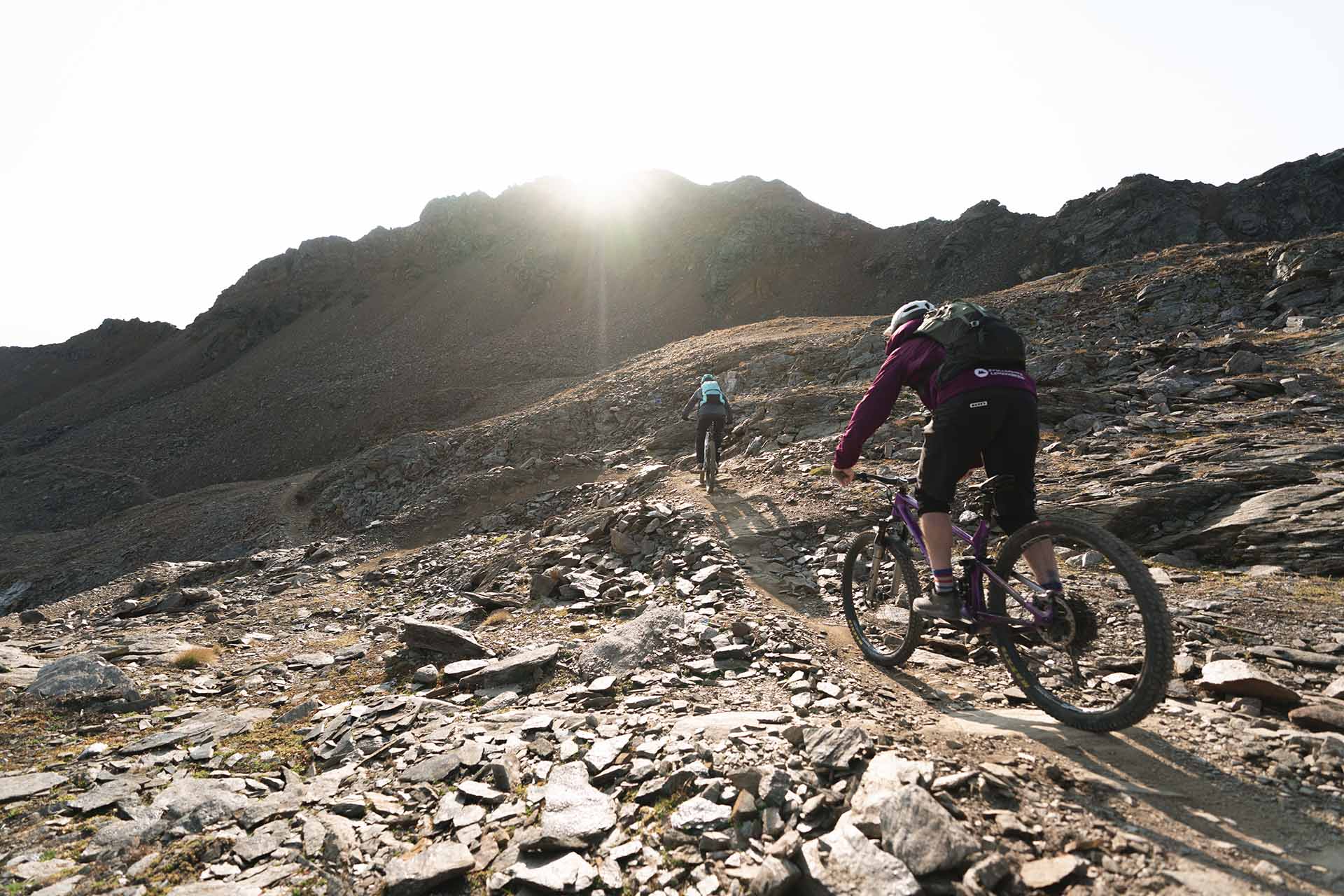 Zwei Biker-Freunde fahren mit ihren Mountainbikes durch die Berge der Lenzerheide