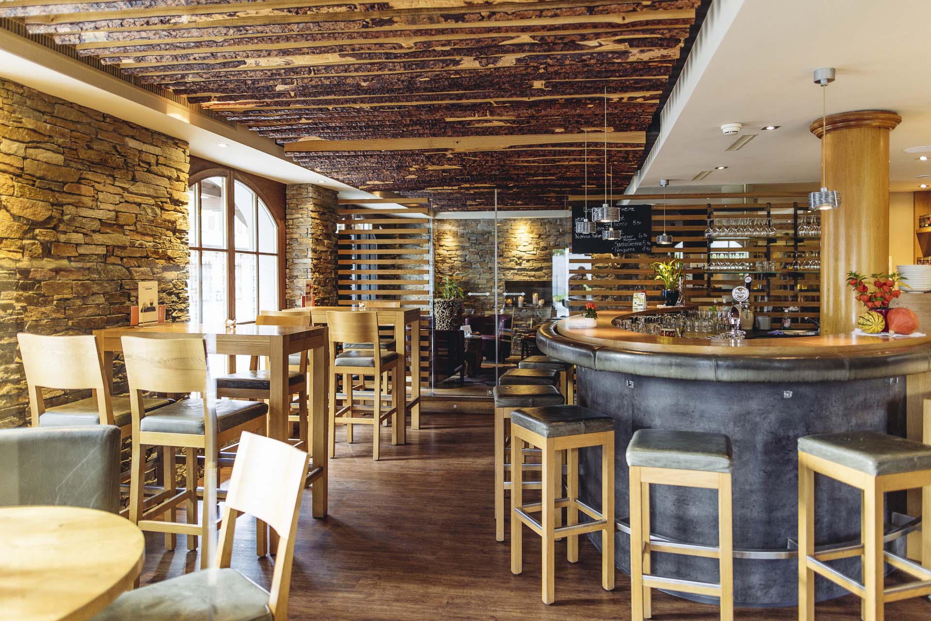 Einladende Atmosphaere mit Weinregal, Tischen und Stuehlen in der Spescha Bar