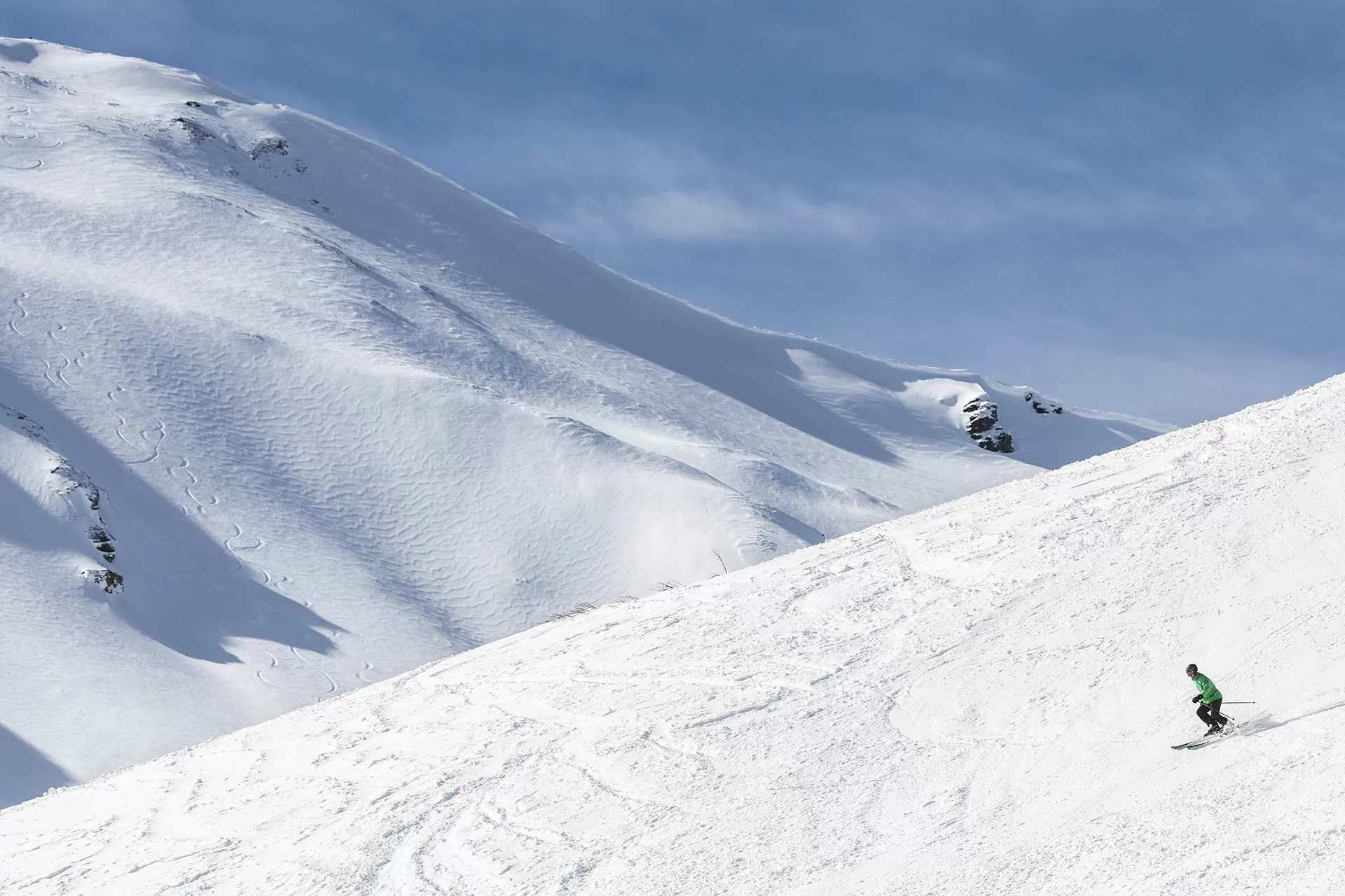 Skifahrer fährt die Piste hinunter bei sonnigem Winterwetter in der Lenzerheide