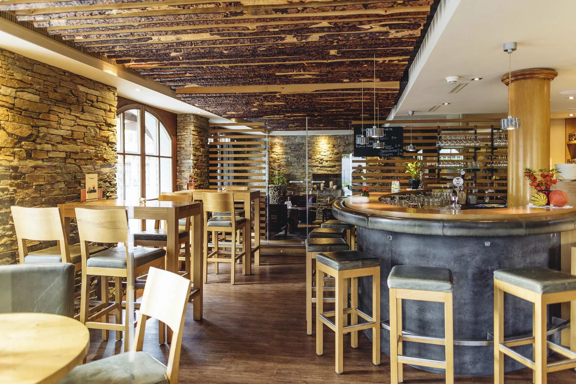 Einladende Atmosphaere mit Weinregal, Tischen und Stuehlen in der Spescha Bar